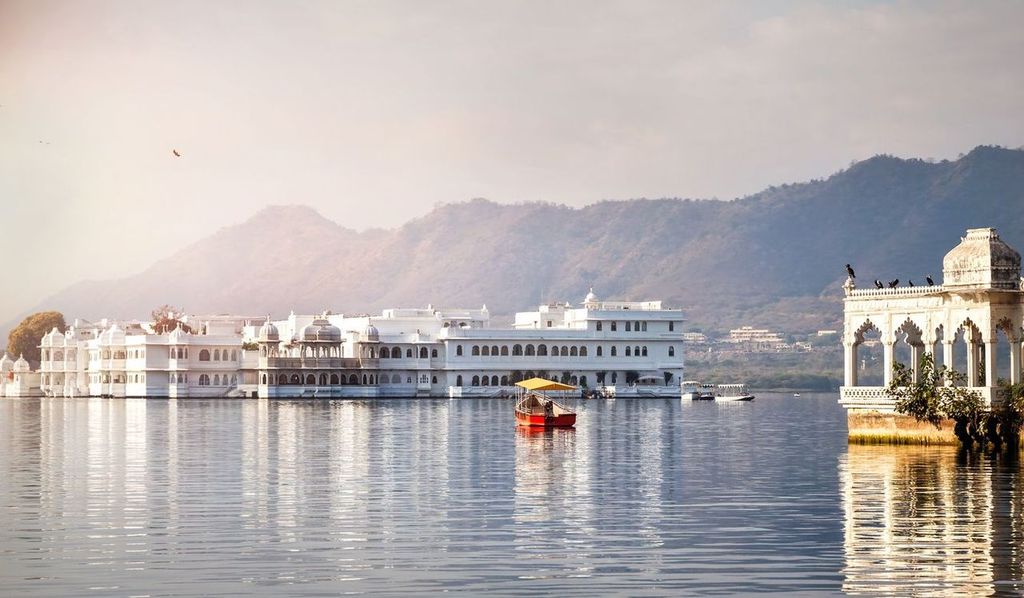 White palace and boat on Lake Pichola in Udaipur, Rajasthan, India