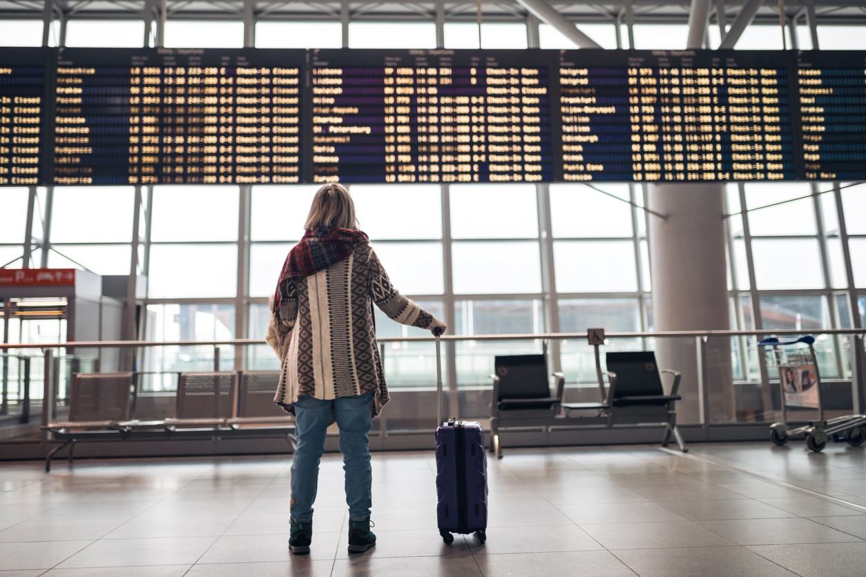 Woman reading departure board on airport.