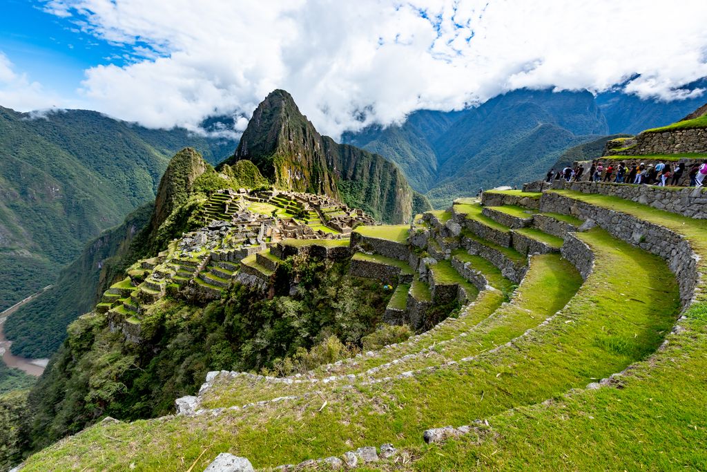 Machu Picchu aerial view with tourists walking through the old abandoned city.
