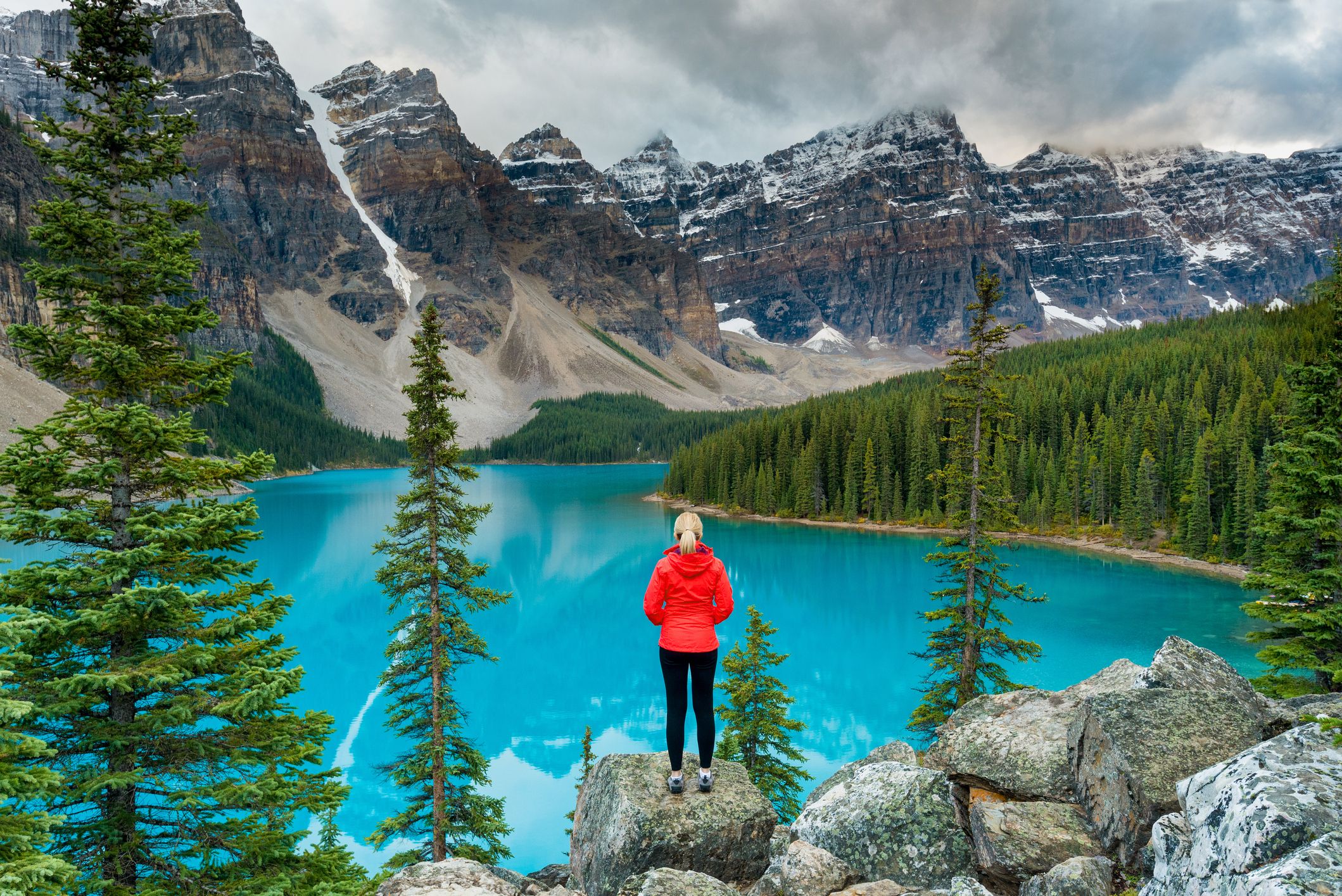 Female hiker stood looking over Lake Moraine, Banff National Park, Canada