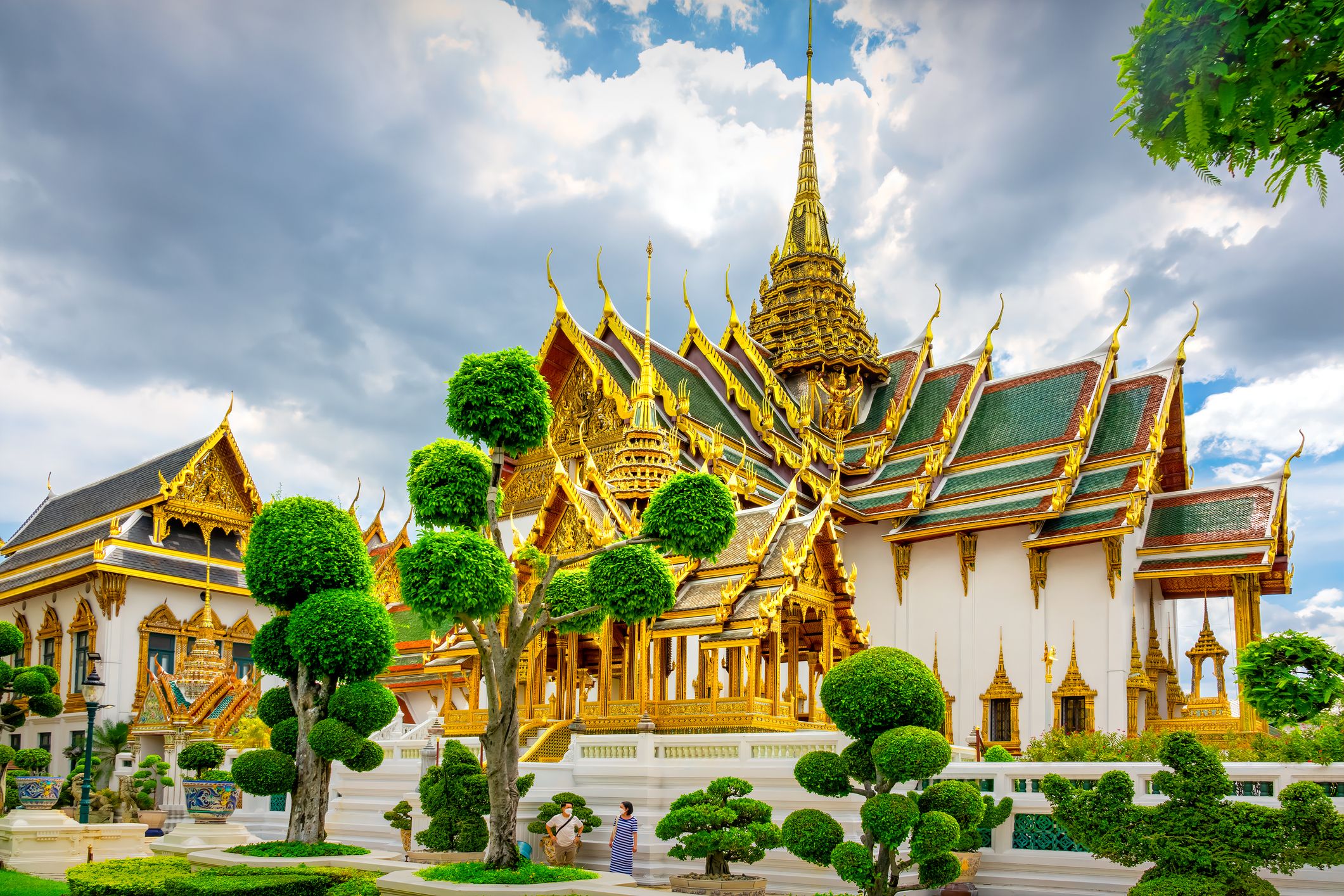 People stand at Phra Thinang Dusit Maha Prasat throne hall building, part of the Grand Palace in Bangkok, Thailand