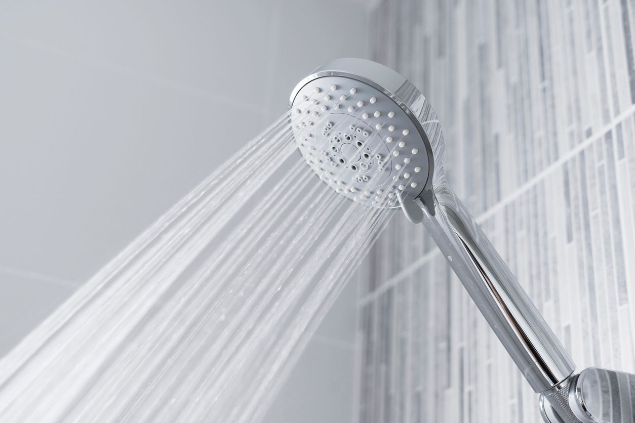 Water running from shower head and faucet in modern bathroom