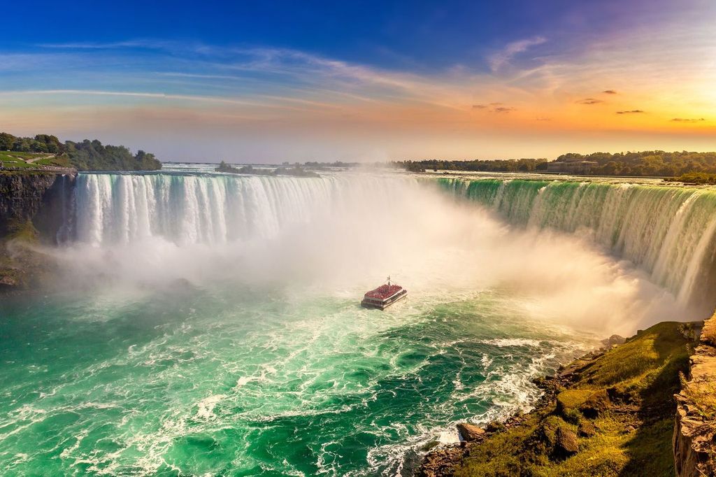 Canadian side view of Niagara Falls, Horseshoe Falls and boat tour at sunset in Niagara Falls, Ontario, Canada