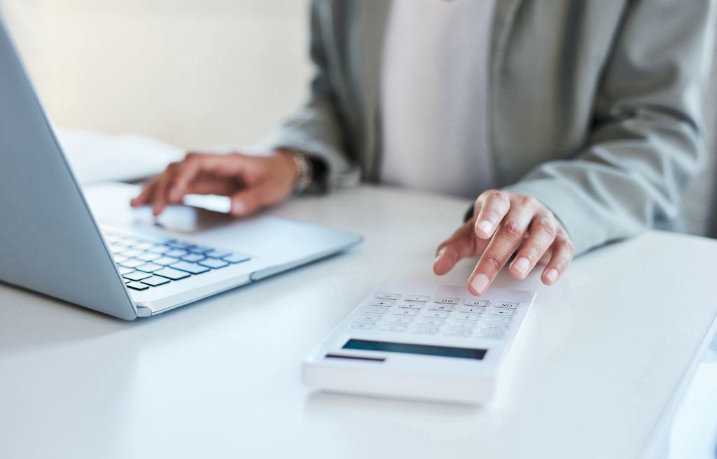 Travel agent using a calculator and laptop