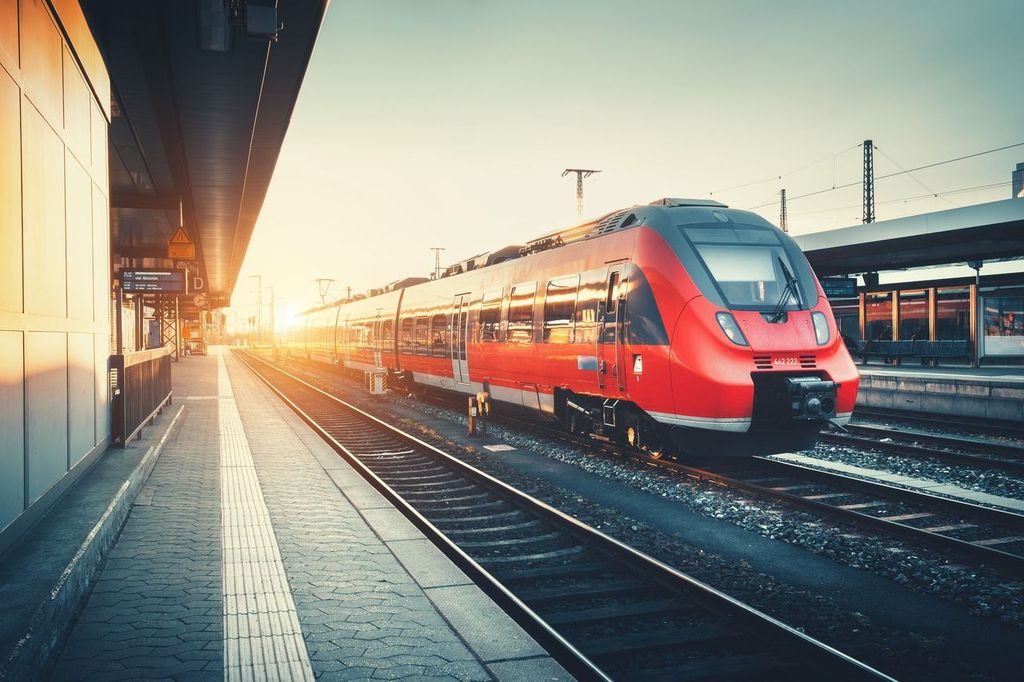 Railway station with beautiful modern red commuter train