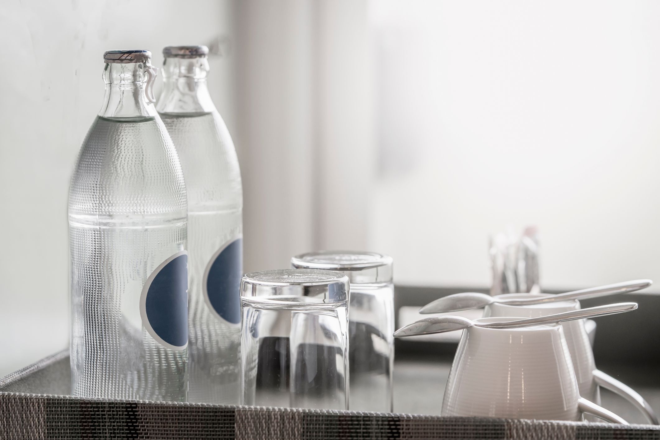 Two bottles of mineral water in the hotel room, as well as clean glasses on a tray