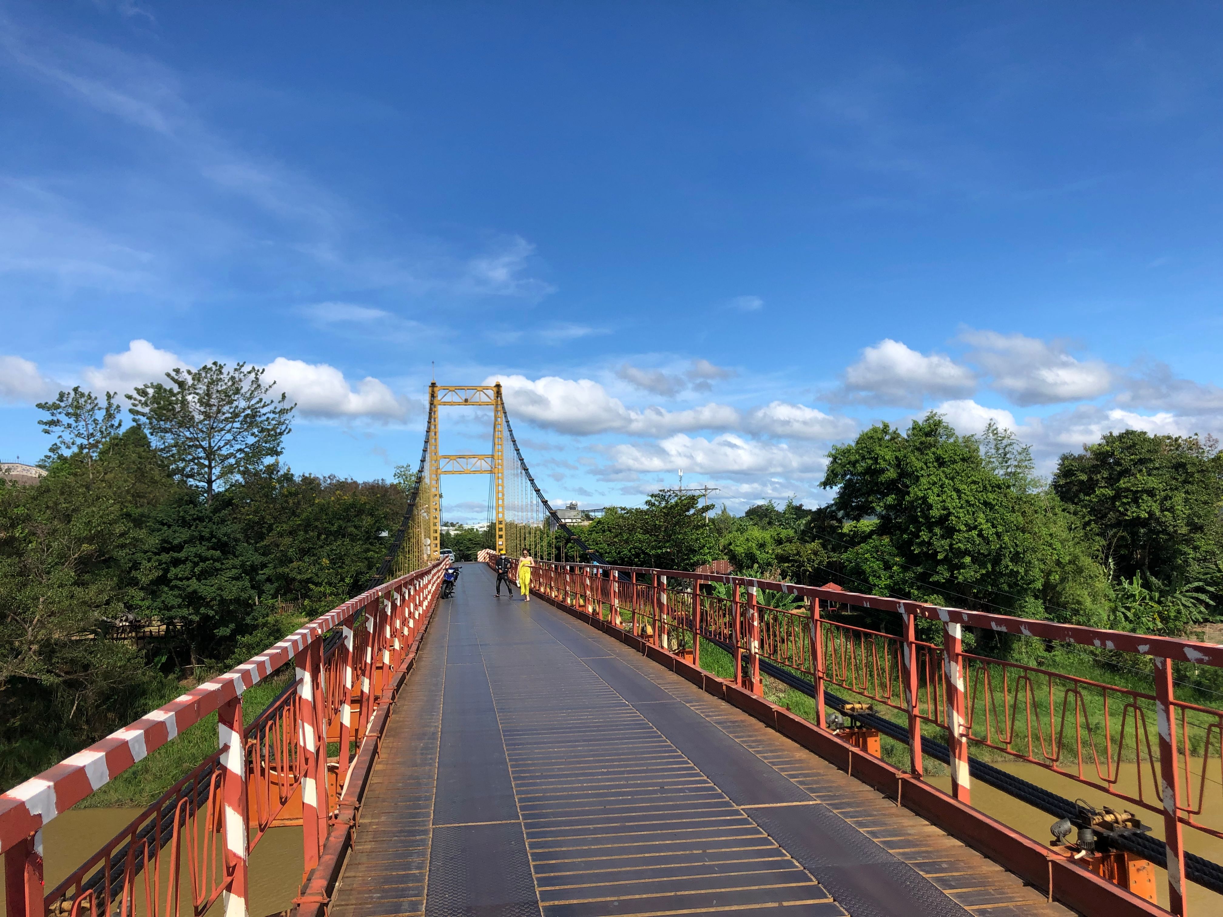 People walking on the Kon Klor Suspension Bridge in Kon Tum, Vietnam