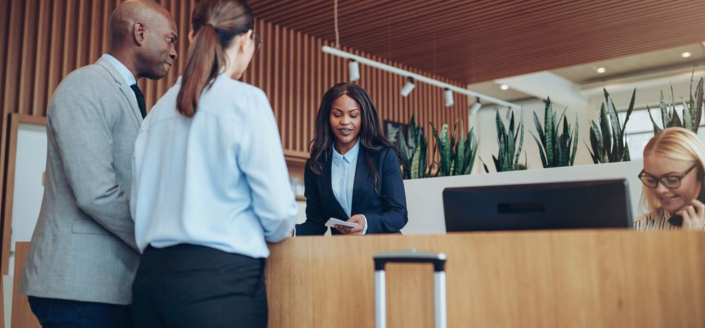 Receptionist helping a couple check into the hotel