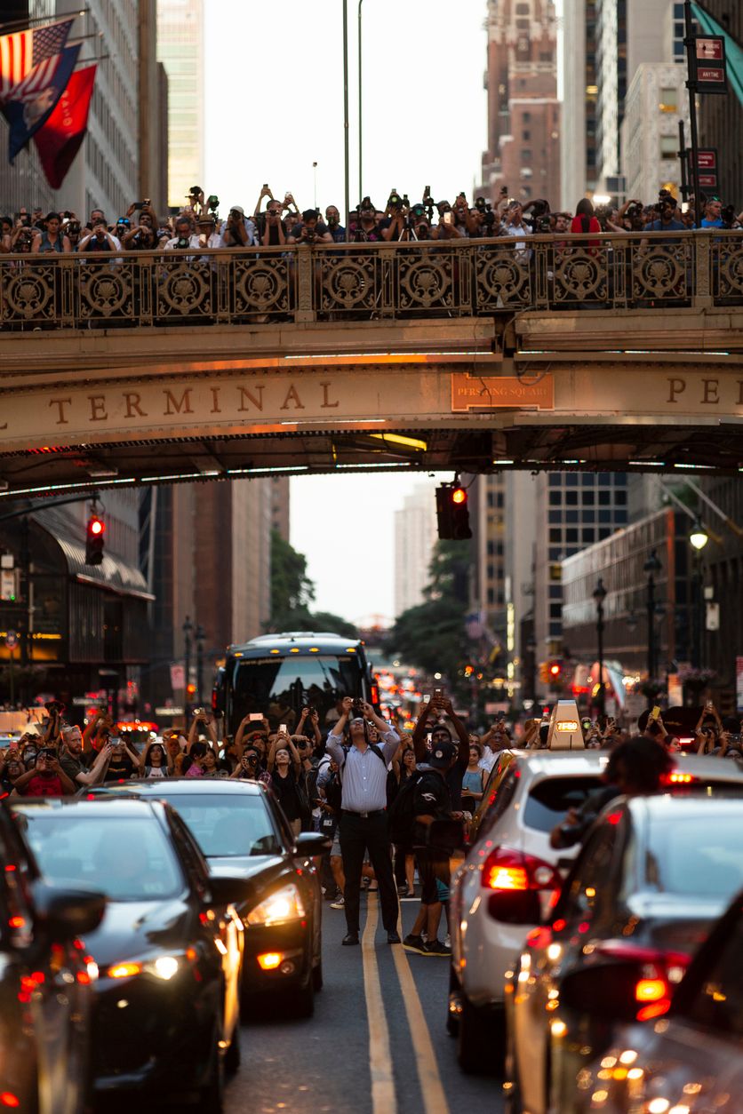 Crowd of people gathered to photograph the Manhattanhenge sunset in midtown.