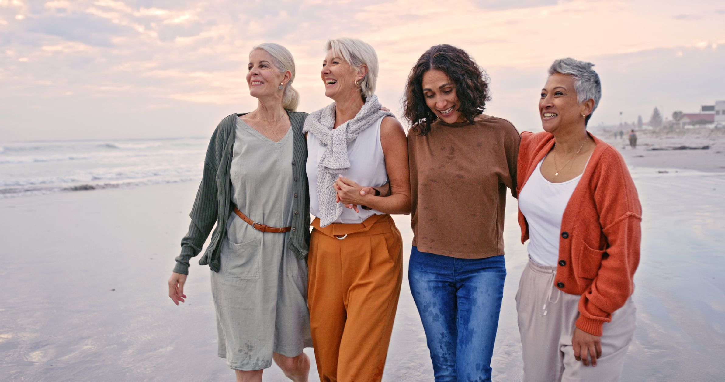 Woman group walking on the sand by the sea enjoying their vacation together