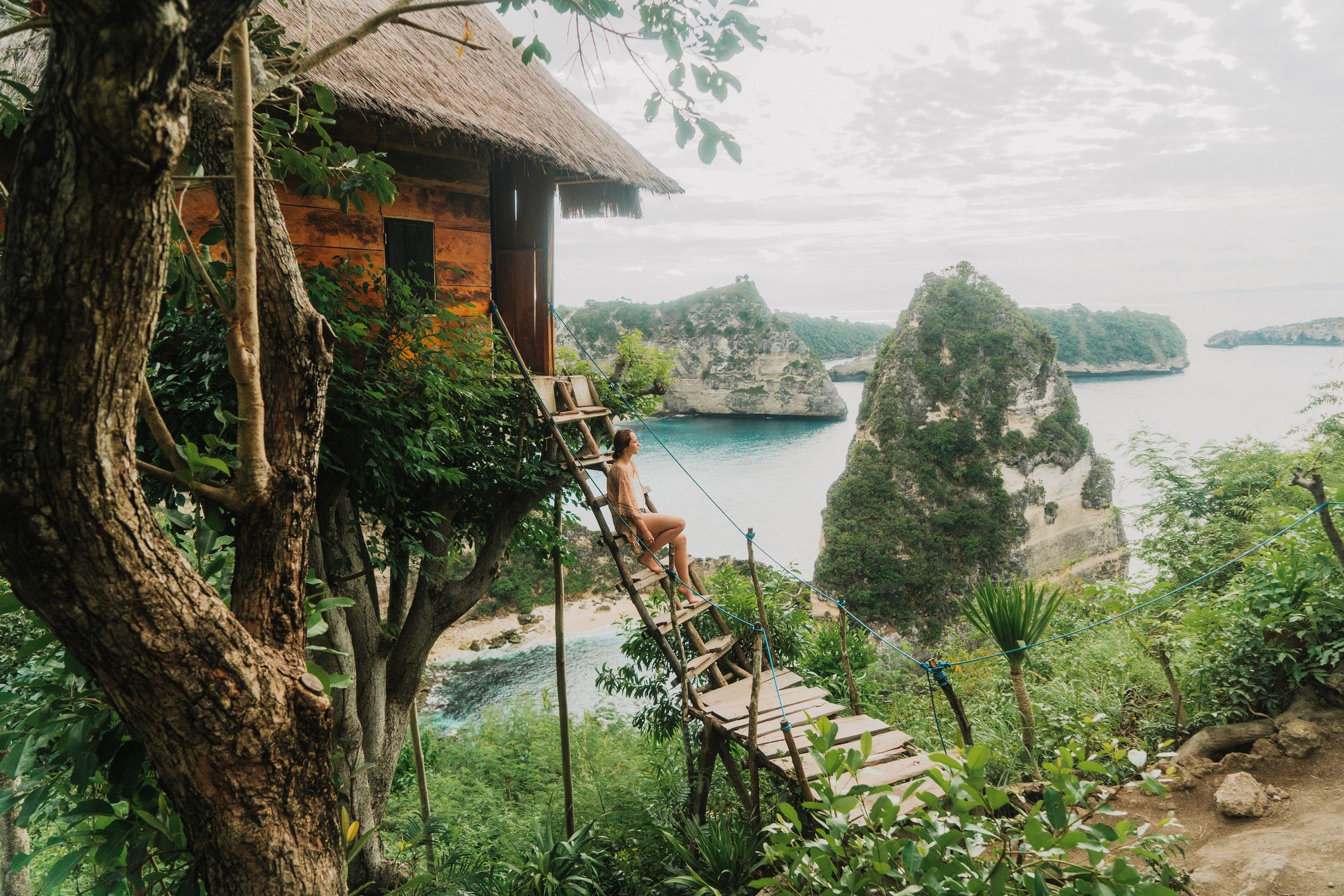 Scenic view of woman near the tree house near the sea on Nusa Penida, Bali, Indonesia