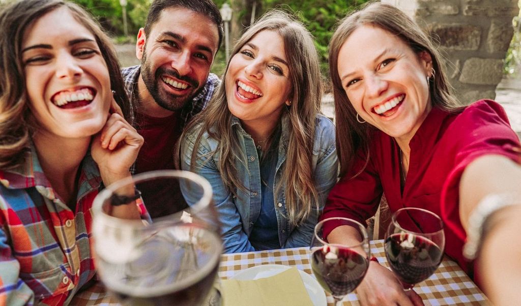 Happy friends having fun drinking red wine together