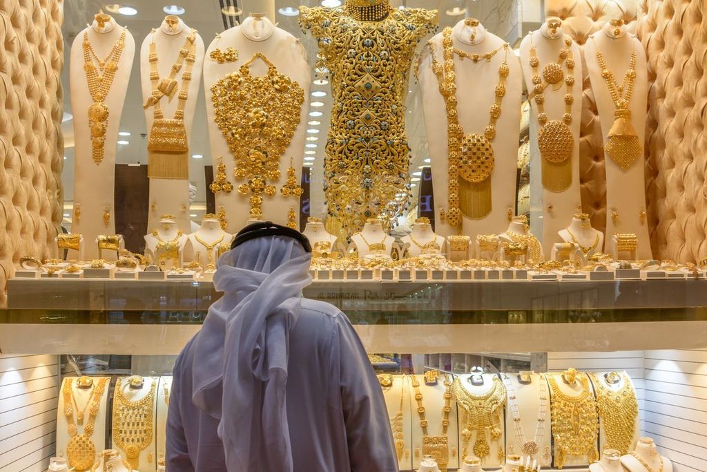 A tourist is busy for exploring heavyweight expensive gold jewellery at Dubai Gold Souk in Dubai, UAE