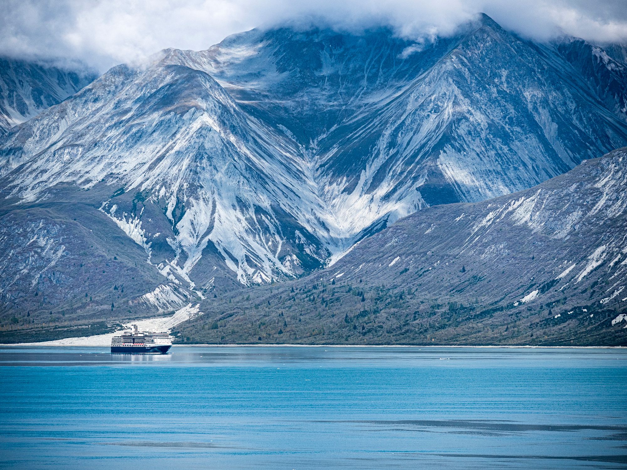 Holland America Line cruise ship sailing through Alaska’s Glacier Bay National Park in late summer.