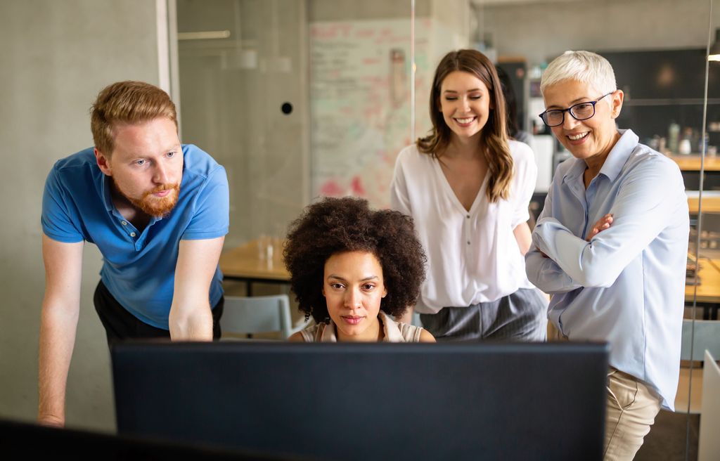 Group of happy business people looking at a computer screen.