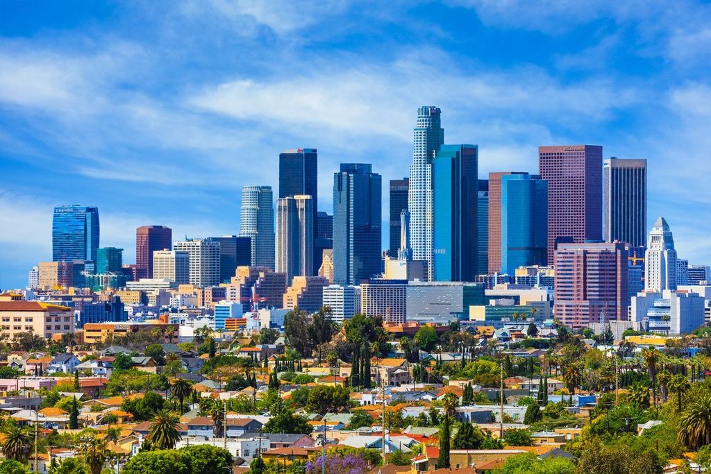 Urban sprawl fills the foreground leading back to the skyscrapers of Los Angeles skyline with cloudscape, California