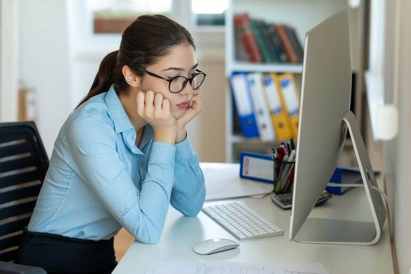 Woman staring at her computer in disbelief
