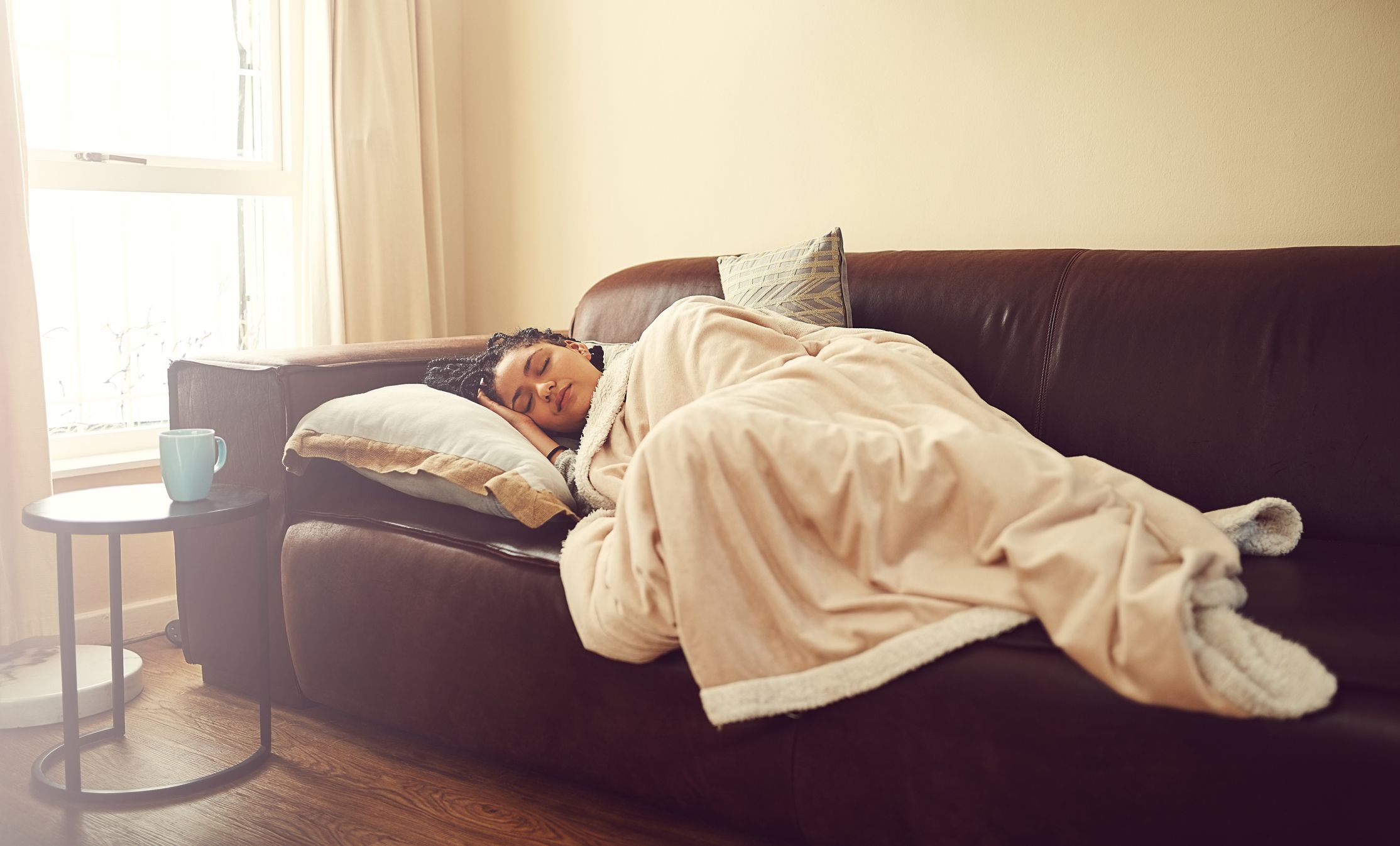  Young woman sleeping on a living room sofa