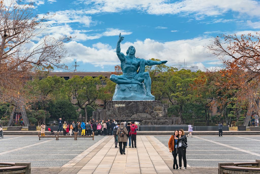 Tourists sightseeing the Peace Statue created by Seibo Kitamura in the Nagasaki Peace Park.