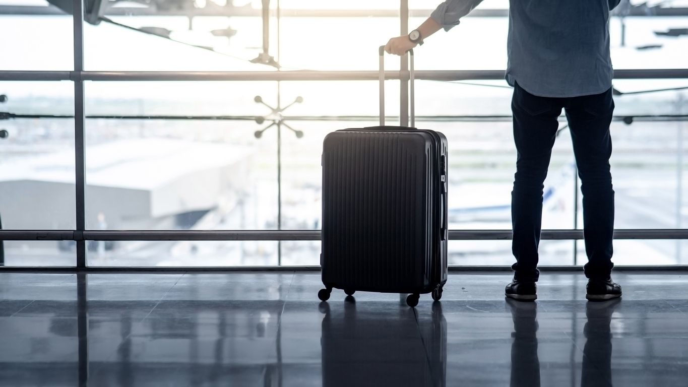 Tourist man holding suitcase luggage in airport