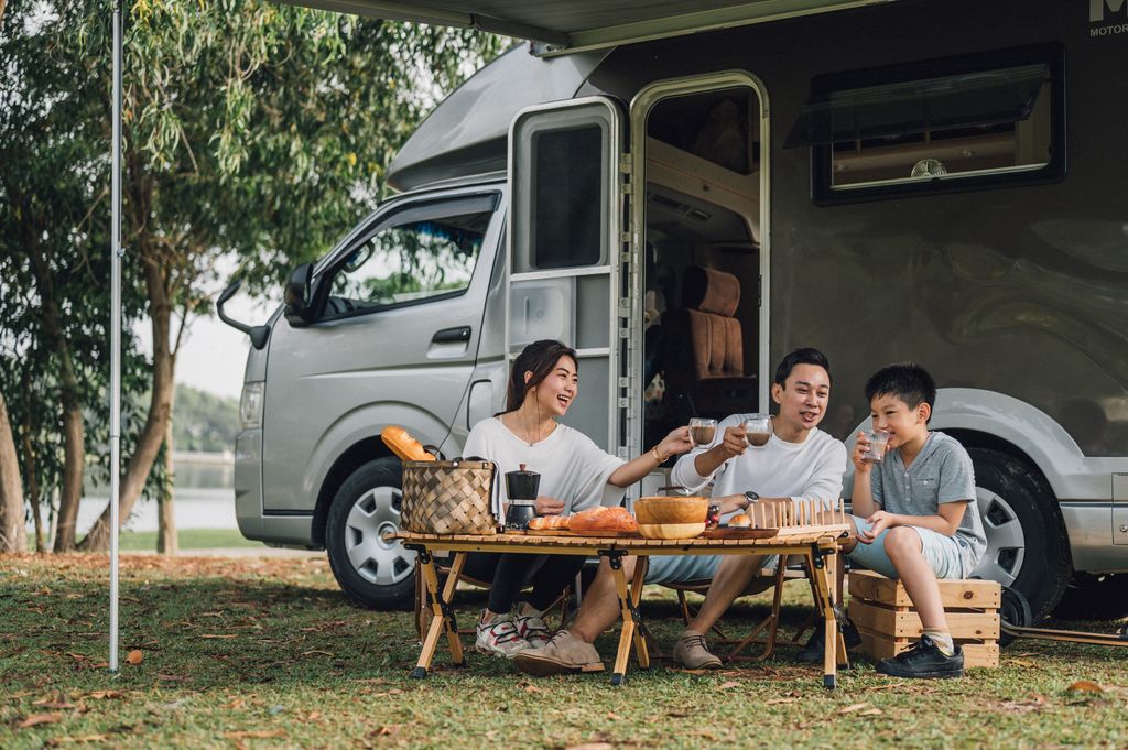 Happy talking at picnic table by the camper trailer in nature