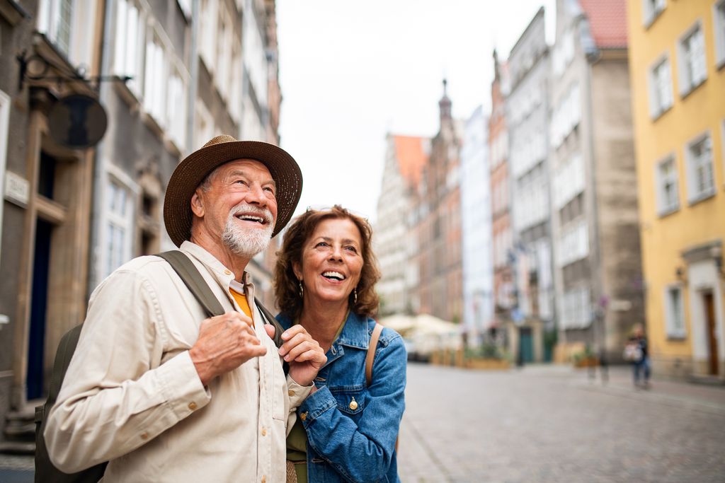 Happy senior couple tourists outdoors in historic town
