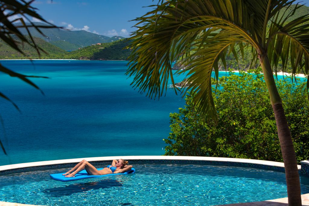 Woman poolside at Luxury villa in Peter bay, Cinnamon Bay, St. John
