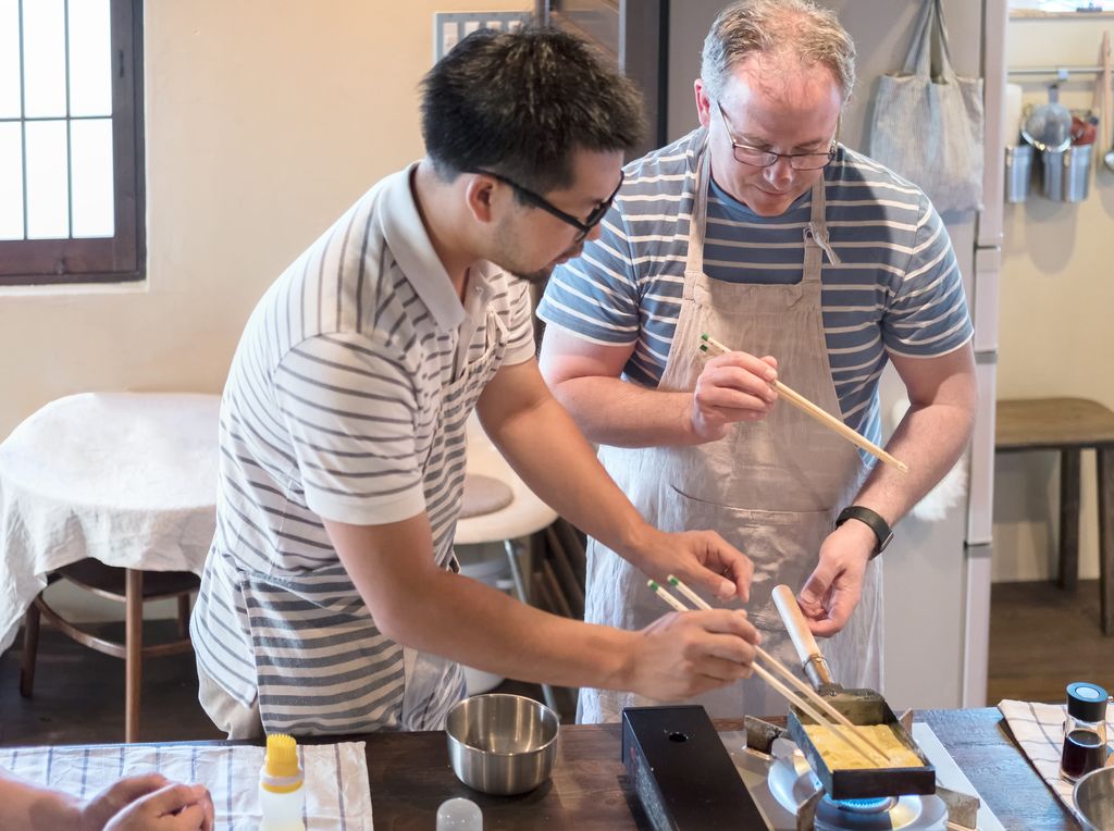Japanese Man Teaching Caucasian Man How to Cook Tamagoyaki Omelette