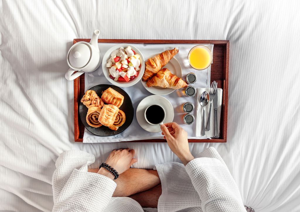 Breakfast in bed on white hotel bedding