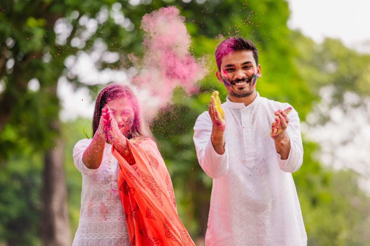 Happy fun loving couple painted in powder colors or gulal and celebrating holi festival