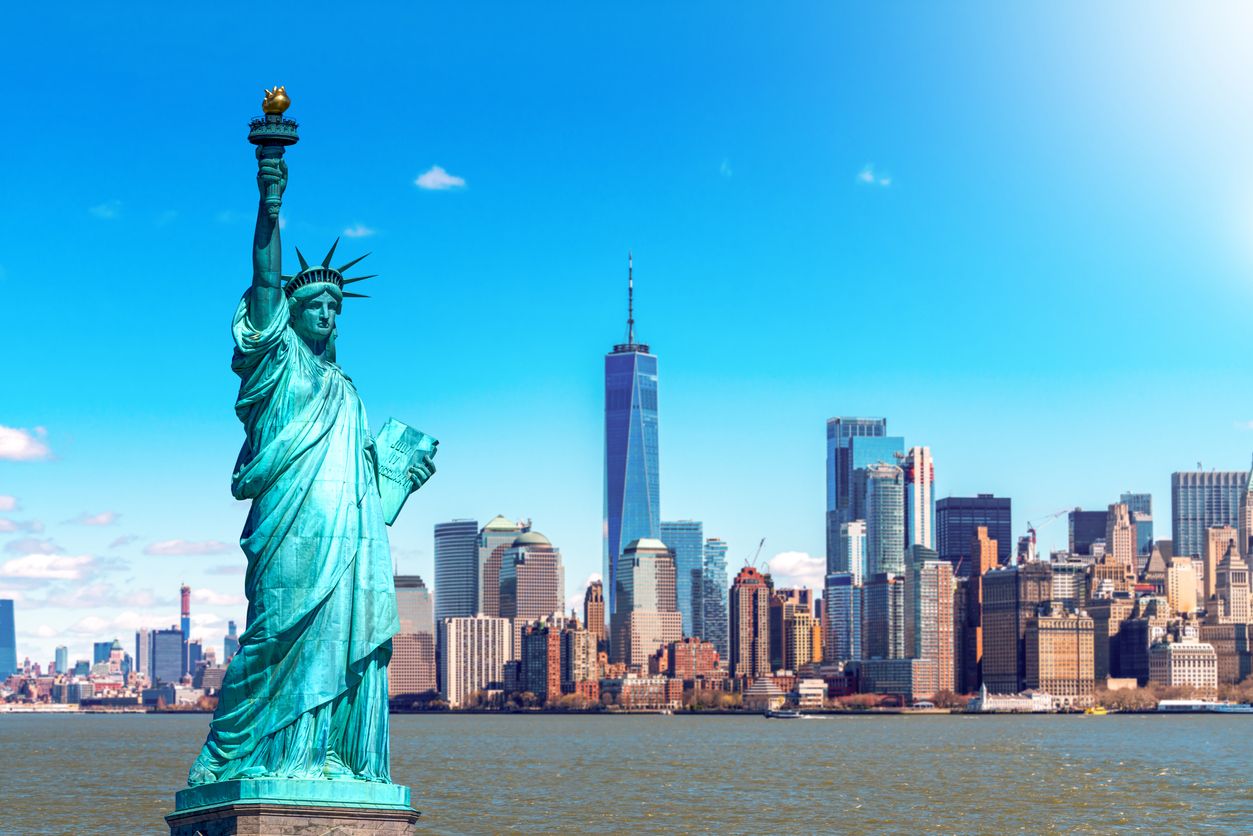 The Statue of Liberty with the One world Trade building center over hudson river and New York cityscape background