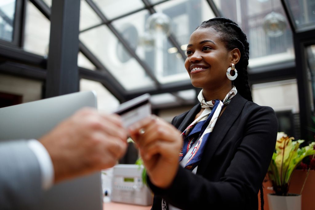 Man paying with credit card at receptionist desk at hotel