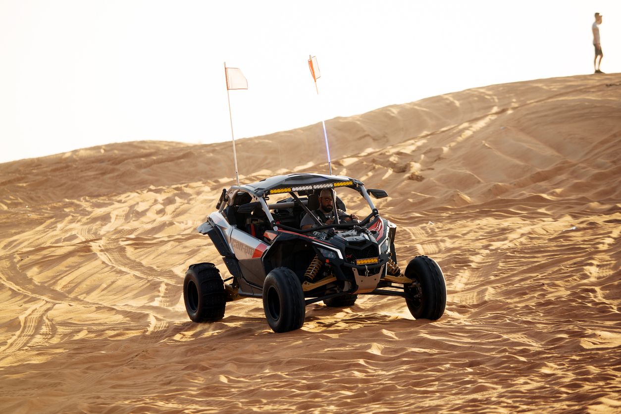 Dune Buggies being driven by tourists at aa Desert Safari park in the red sand dunes near Dubai