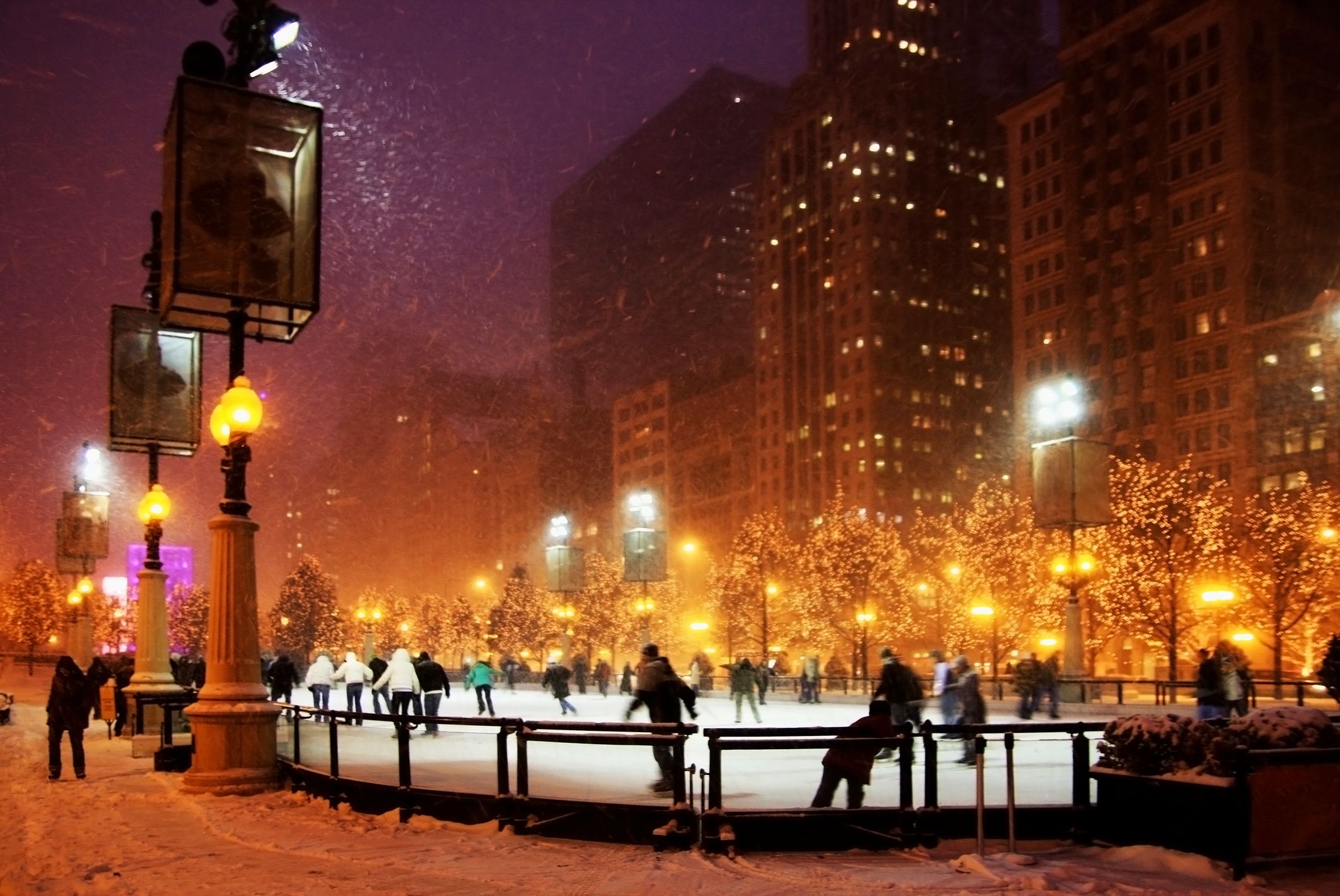 People having fun ice skating at ice rink in downtown Chicago