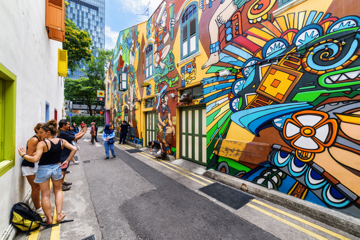 Singapore: Tourists taking a picture of amazing decorative painted wall at Haji Lane. Street art by an unknown artist at the Muslim quarter (Arab quarter). Graffiti in Singapore.