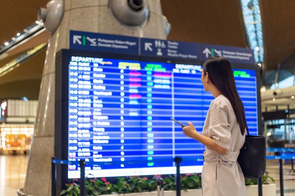 Woman checking flight schedule in airport