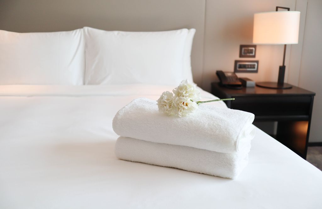 Clean white bath towels on the neatly clean hotel bedroom
