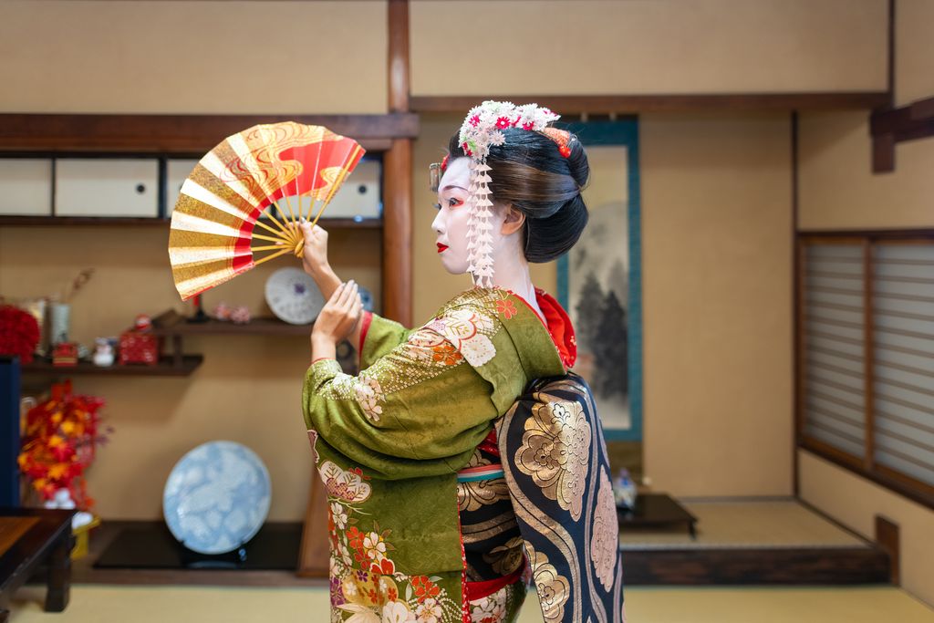 Maiko (Geisha in training) dancing with 'Sensu' folding fan in Japanese tatami room