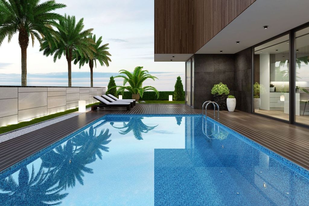 Luxurious beach side villa with swimming pool and palm trees.