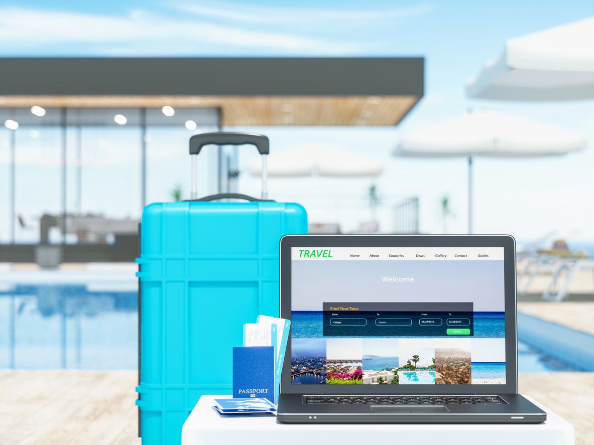 Laptop with suitcase near the luxury resort