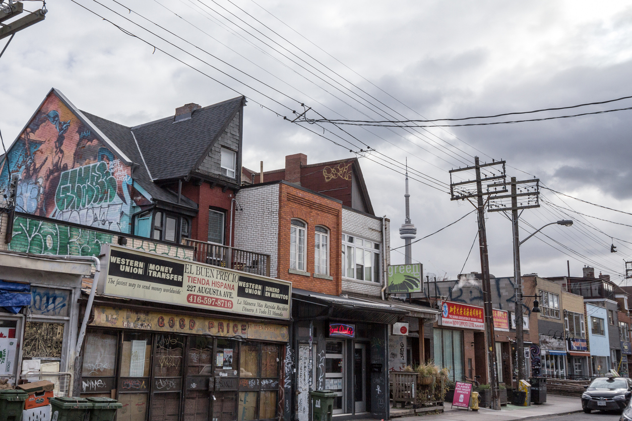 Pictures of a typical street of kensington market, in the center of Toronto, Ontario, Canada with the CN tower in background.