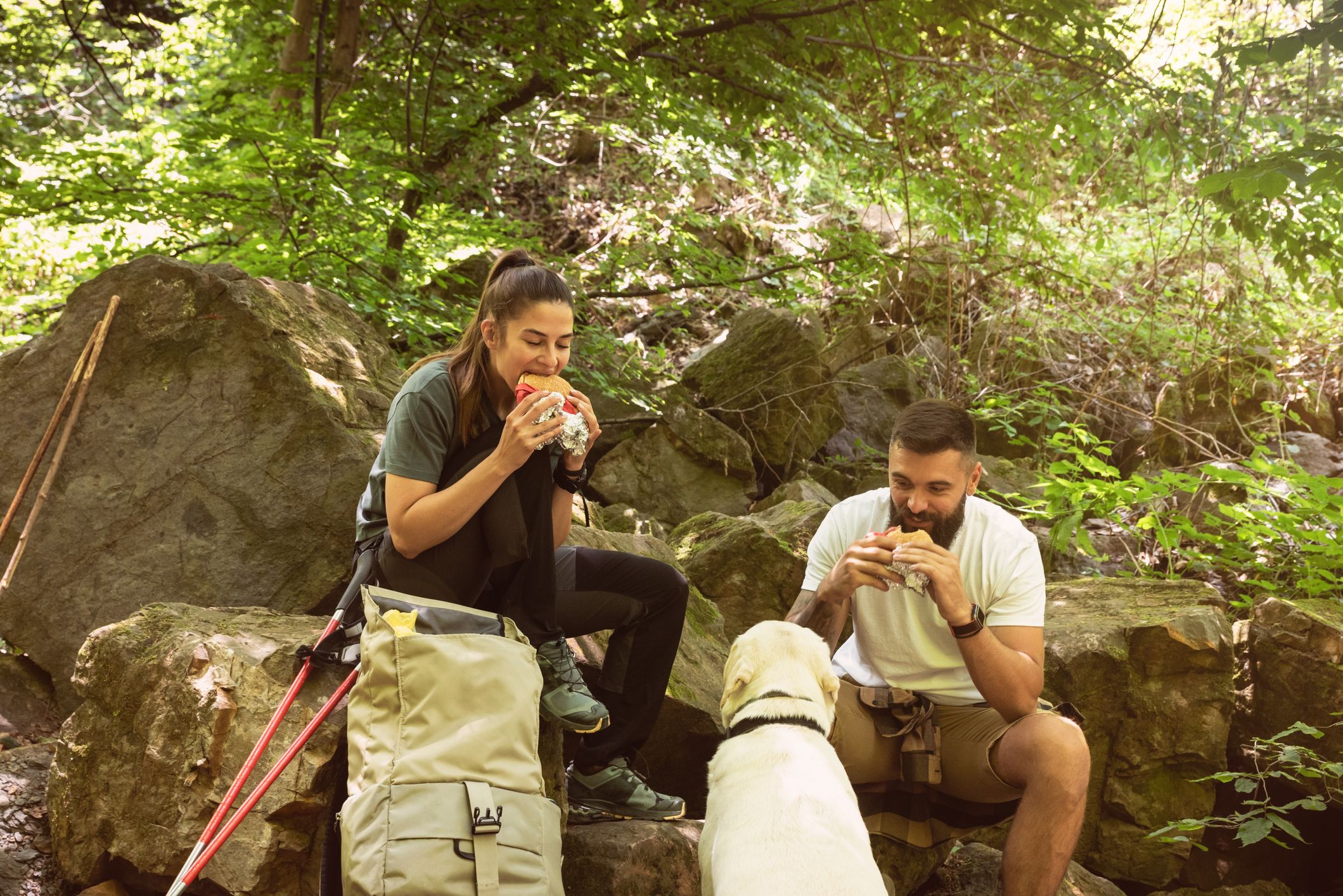 Nature lovers hiking through the forest eating lunch