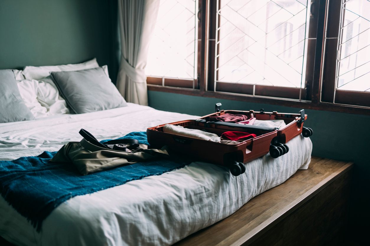 A View Of A Bedroom With An Open Luggage On The Bed