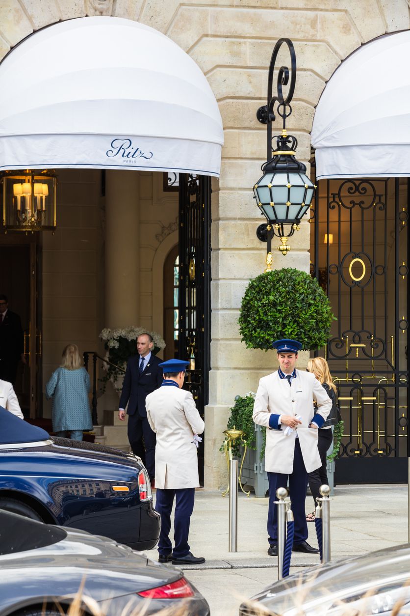Doormen with uniform meet tourists at the entrance to the Ritz Paris hotel on Place Vendome