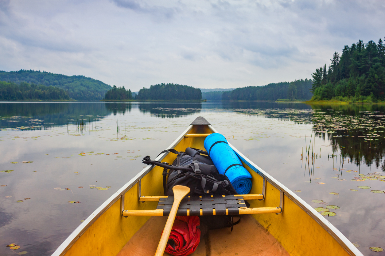 Point of view stock photograph of a canoe with backpack in the Ontario lake country, Algonquin Provincial Park, Canada