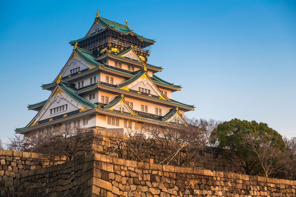 Osaka Castle illuminated by warm light of sunset Japan