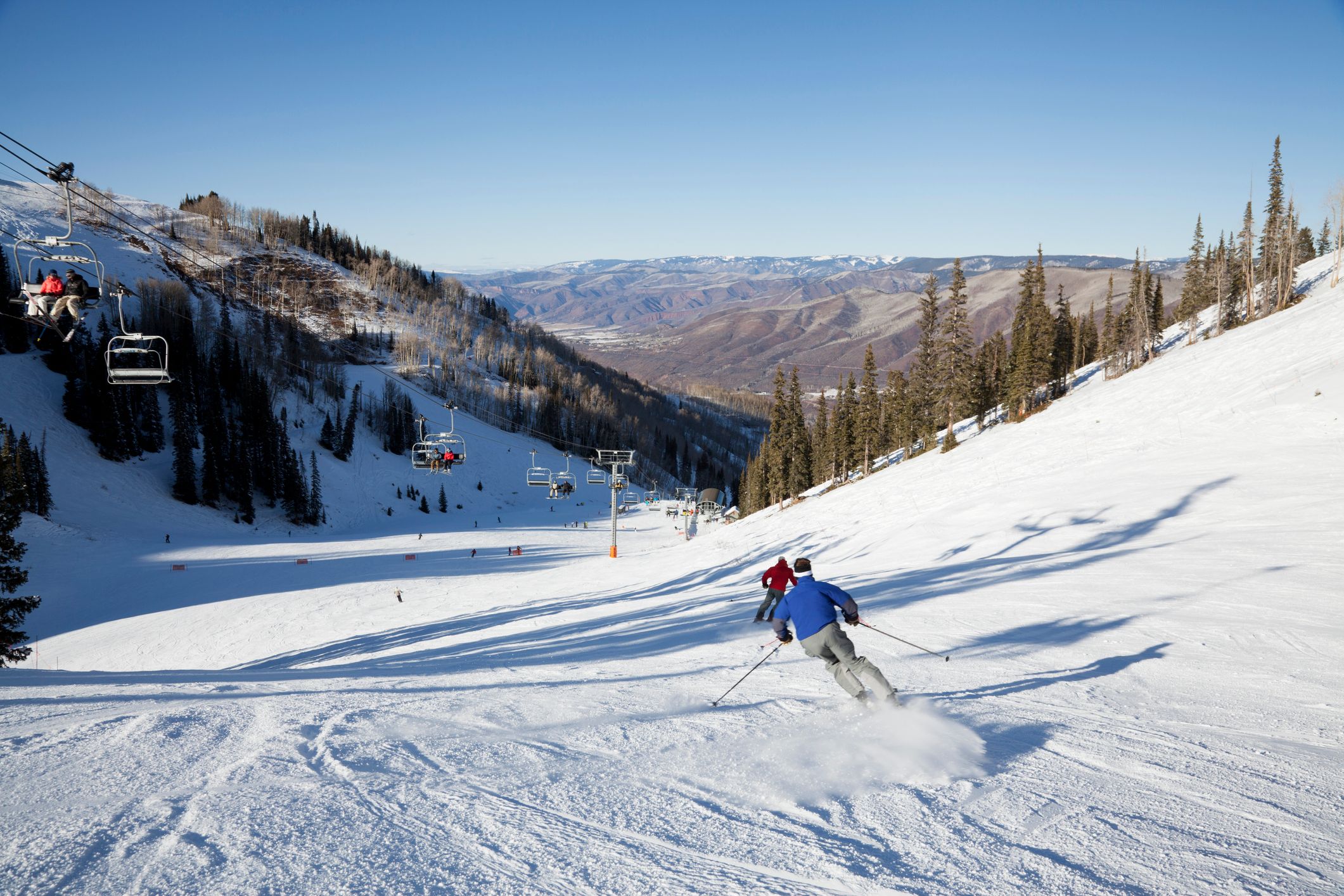 skiers rocket down a groomed trail on Ajax Mountain at Aspen Colorado