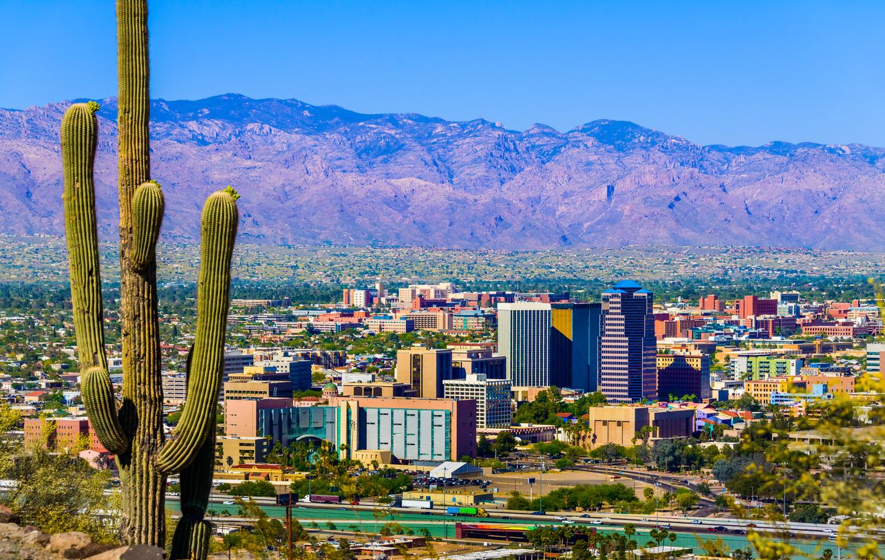 Tucson Arizona skyline cityscape framed by saguaro cactus and mountains
