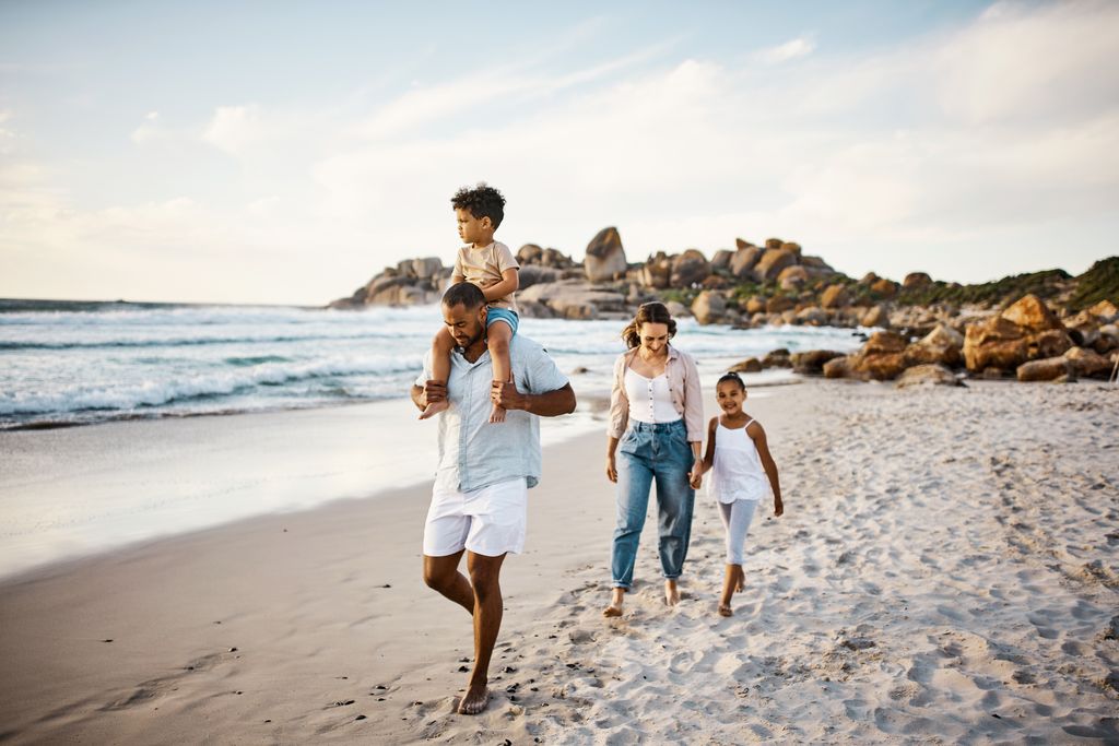 Shot of a young couple and their two kids spending the day at the beach