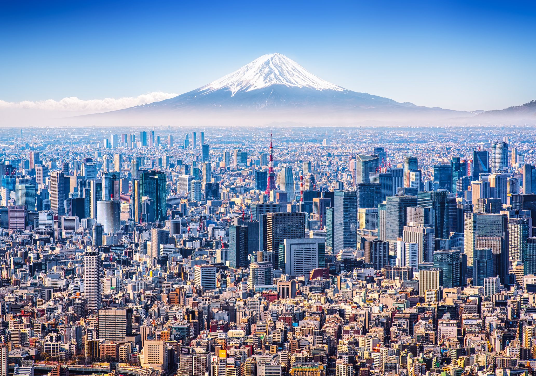 Aerial view of Mount Fuji, Tokyo Tower and modern skyscrapers in Tokyo on a sunny day